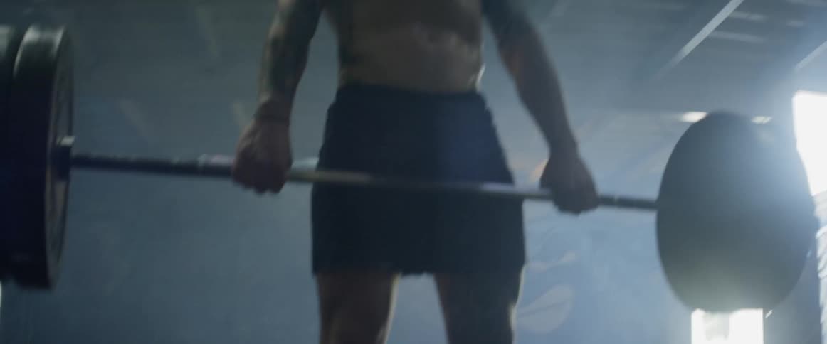Man lifts a barbell then sits it on the floor