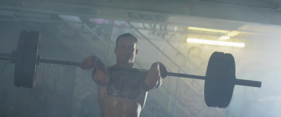 Man lifts a barbell up to his shoulders then drops it on the floor