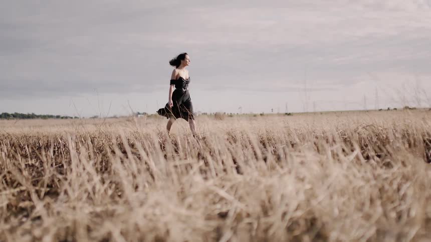 Woman walks across a rural field