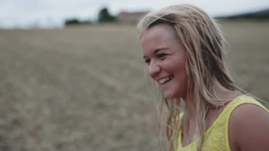 A woman laughs on the field