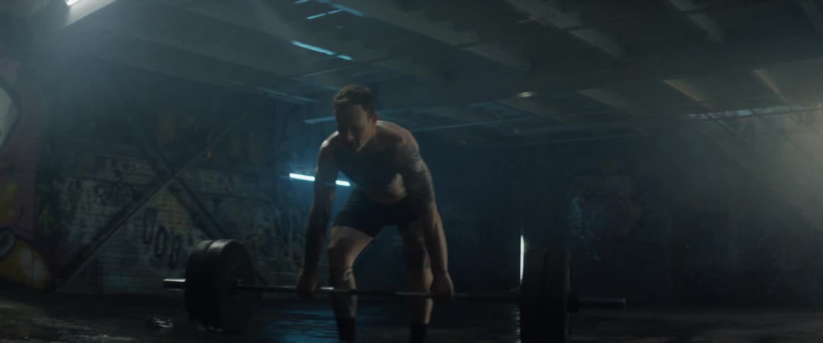 Man lifts weights in a wet building