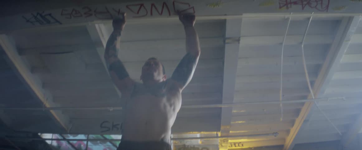 Man does chin ups on a roof rafter