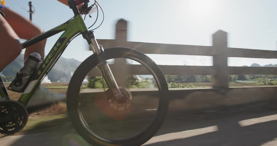 A person is riding their bicycle over a small bridge