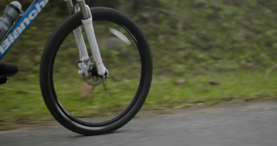Man pedals a bicycle as he rides down the road