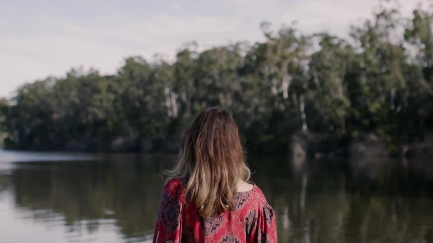 A woman walks over to the lake
