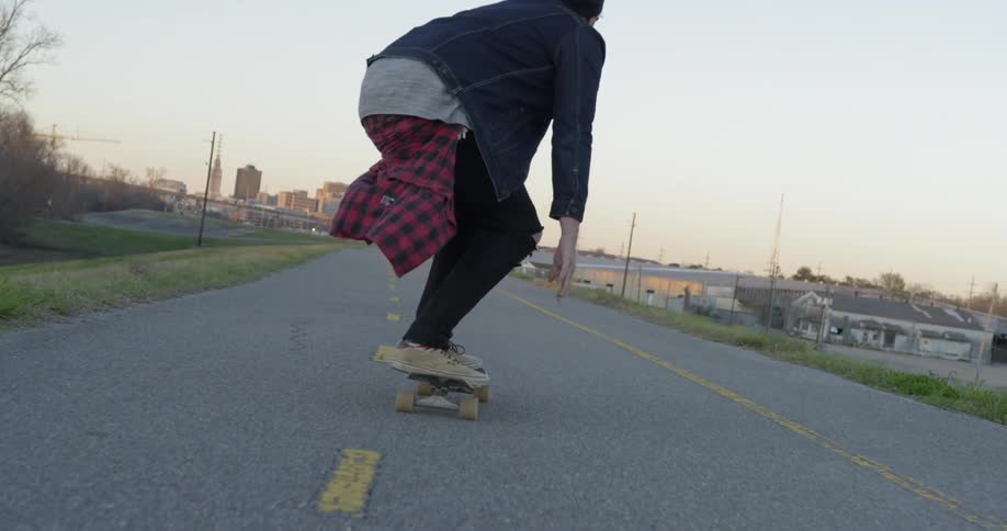 Man rides a skateboard at sunset