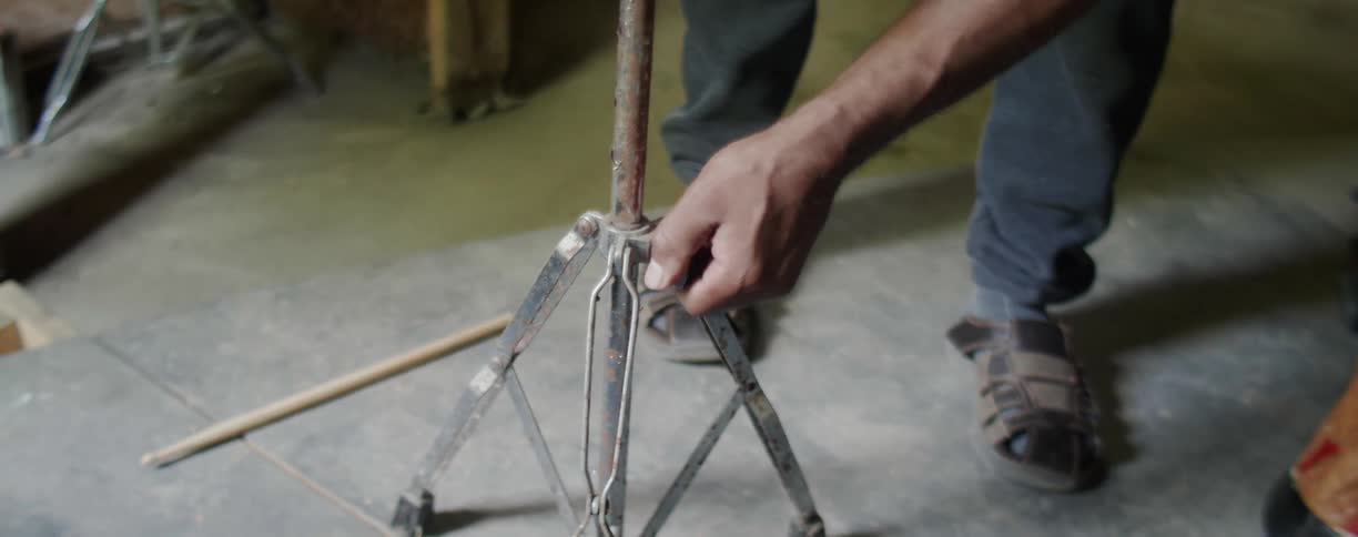 Man tightens a cymbal stand