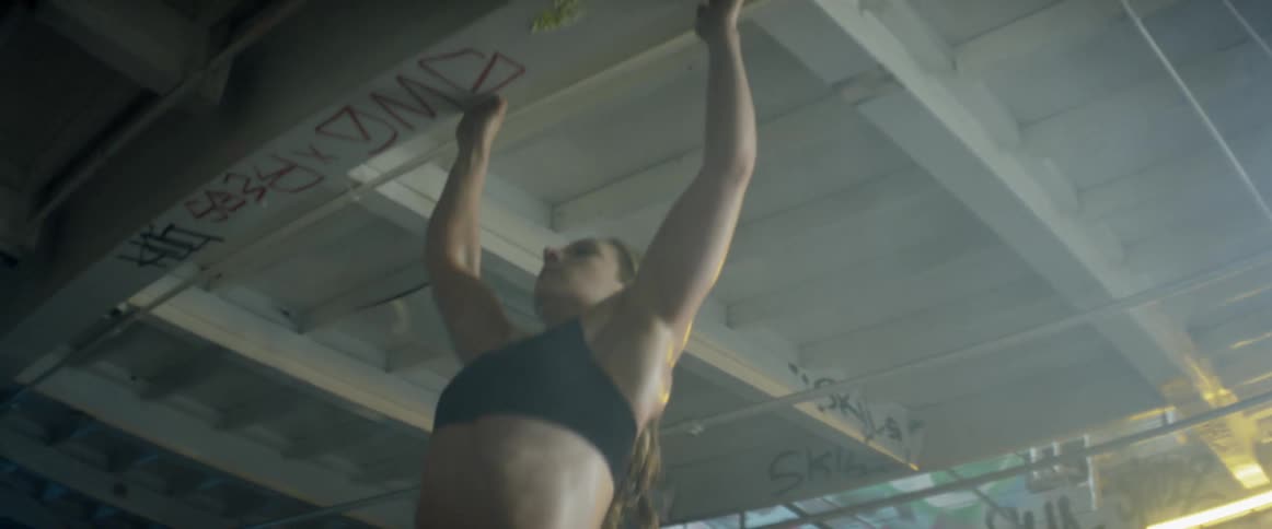 Woman does pull ups in an abandoned building