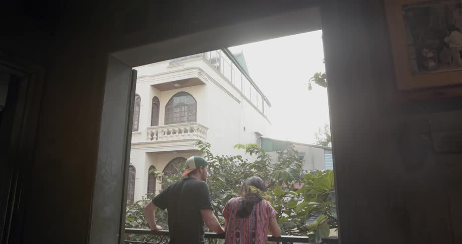 Man and woman stand on a balcony