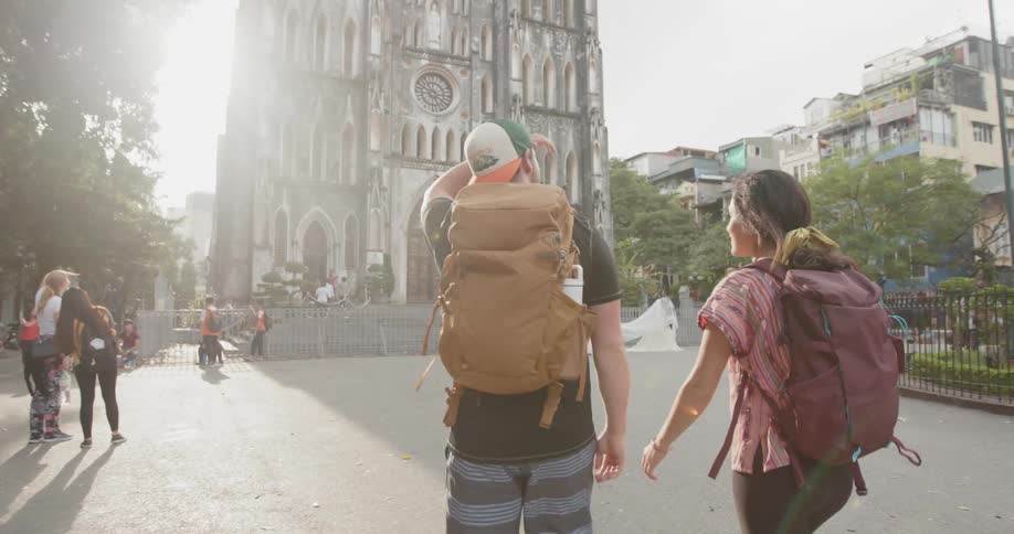 People walk towards a tall building ahead