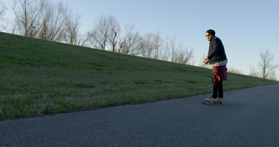 Person skateboarding in park at sunset