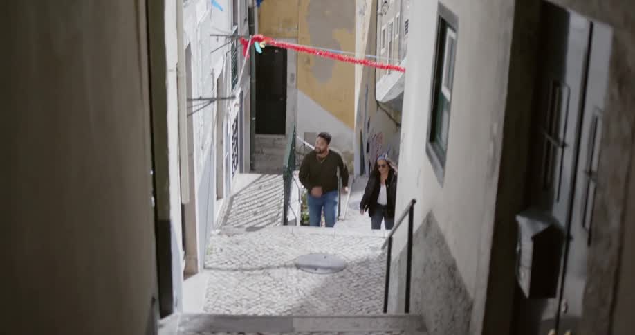 Man and woman climb steps in an old village