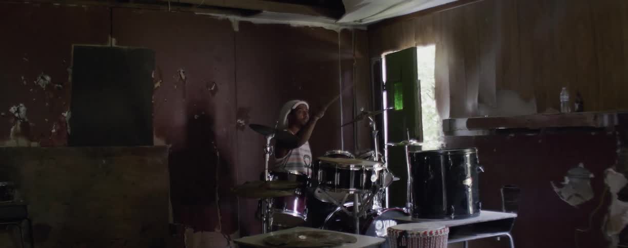 A man is playing drums by the door