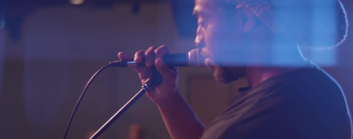 Man adjusts a microphone on stage