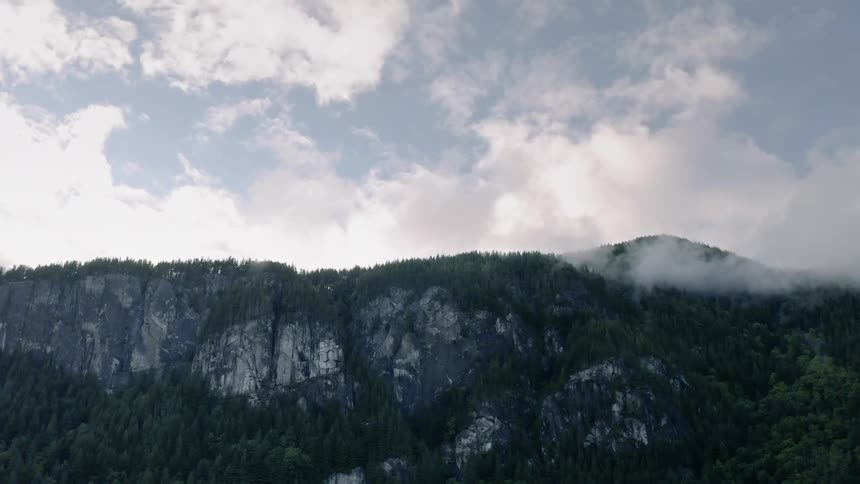 Clouds pass above the tall cliffs - 4K Aerial