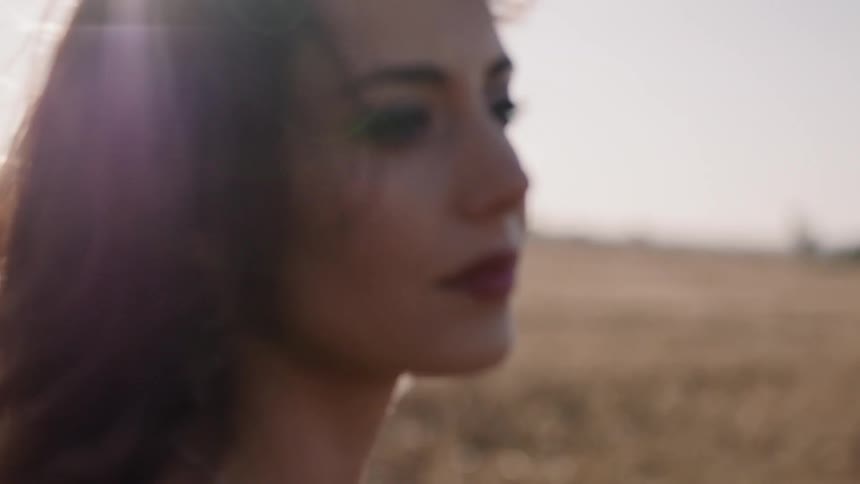 Woman stands in a rural field on a windy day