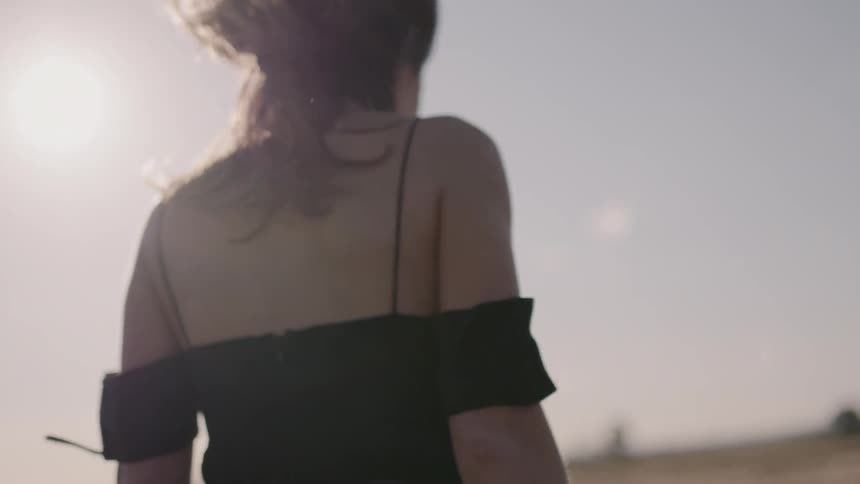 A woman walks outside on a very windy day
