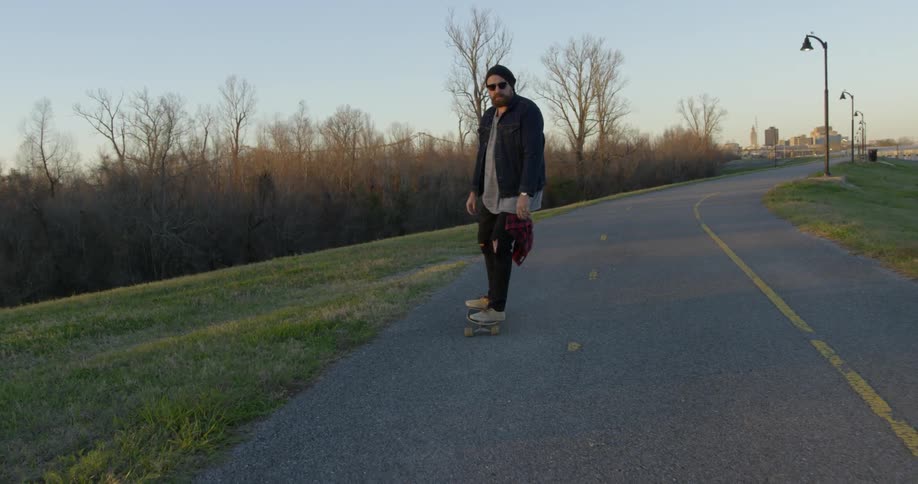 A man is riding his skateboard downhill