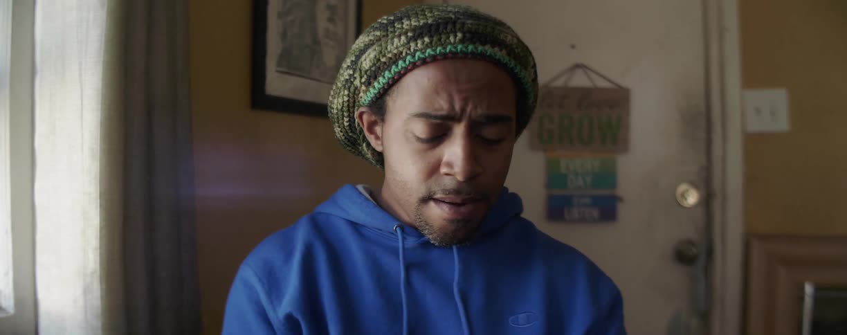Man in a knitted hat sings as he shakes his head