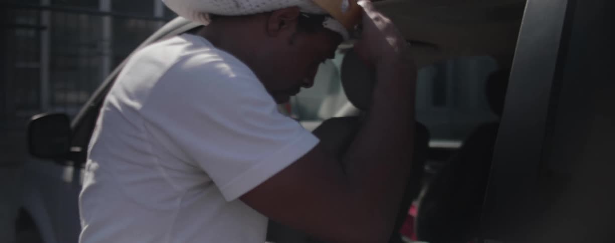 Man removes tambourine from van and places it on his head