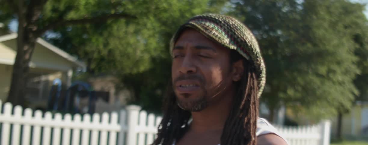 A man in a beanie hat walks down the street