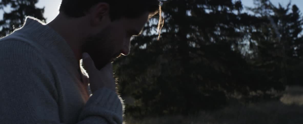 The sun shining down on a man as he walks in the woods