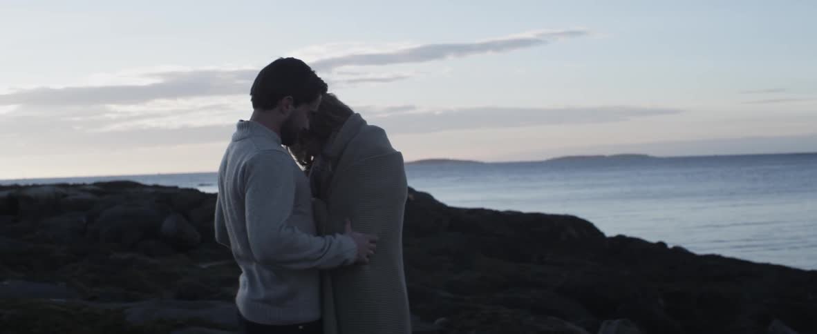 Man and woman hug near the coast
