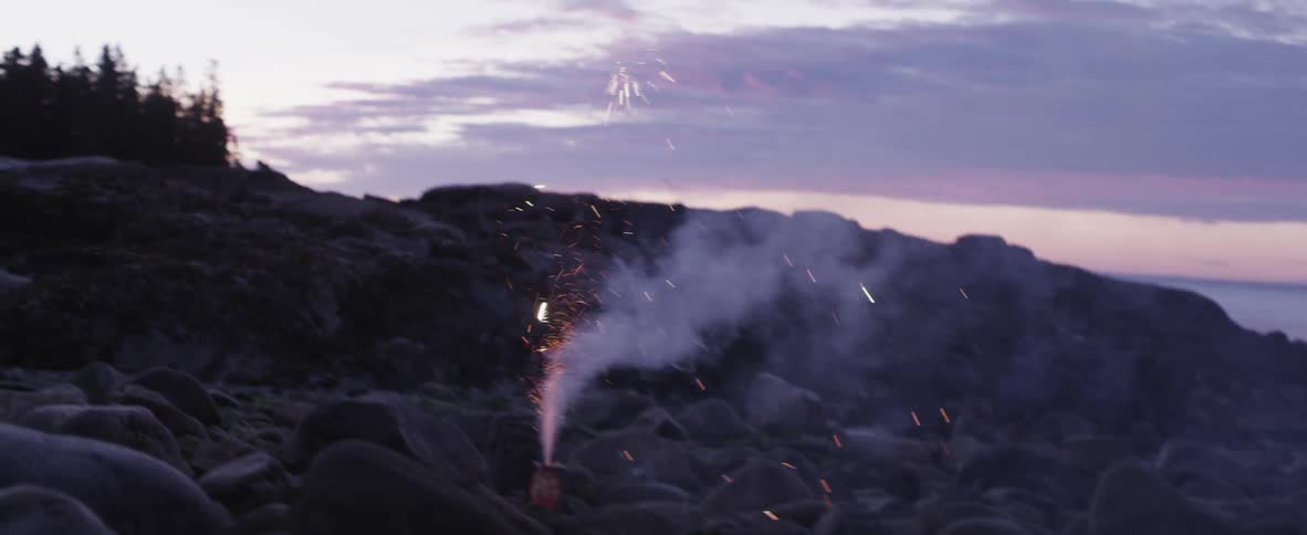 Smoke, sparks and fireworks erupt from a canister among the rocks