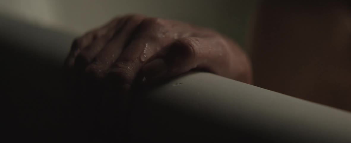 A woman sits up in the bathtub