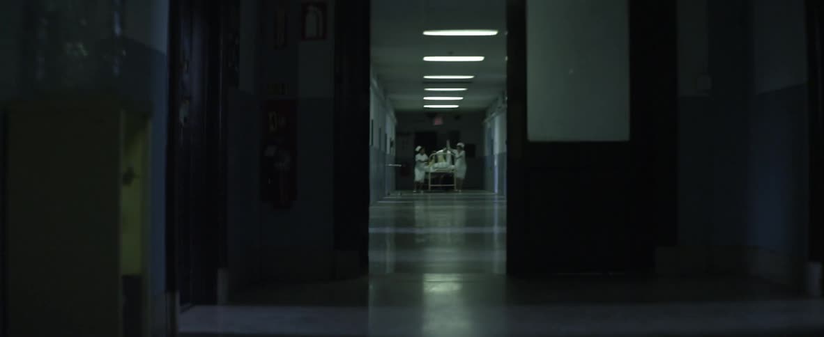 Nurses rushing a patient on a gurney down a hospital hallway