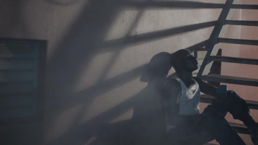 A man exhales to catch his breath at the bottom of the stairs