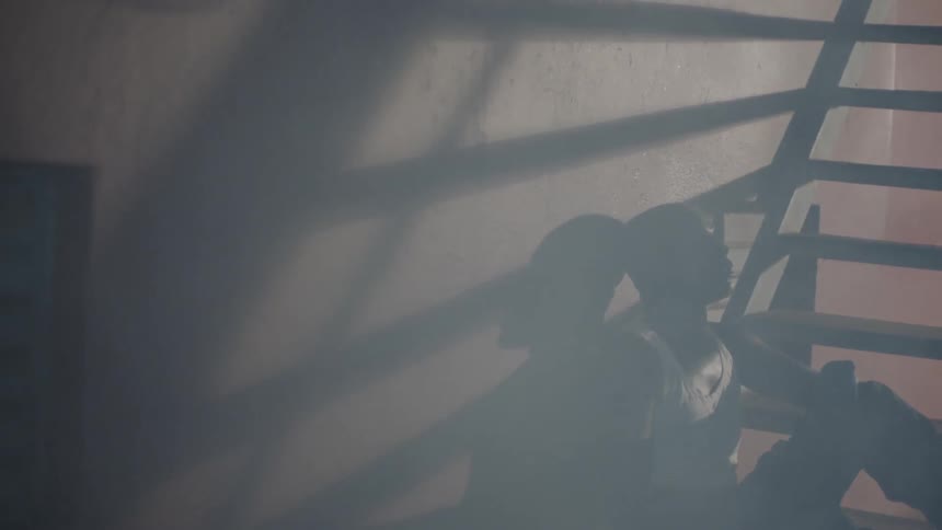 Man sits on the floor as smoke floats by