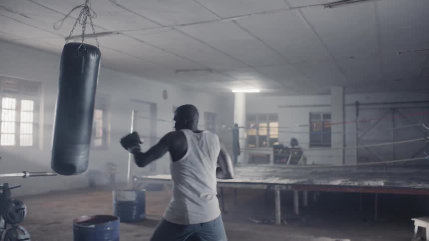A man trains on a heavy punching bag