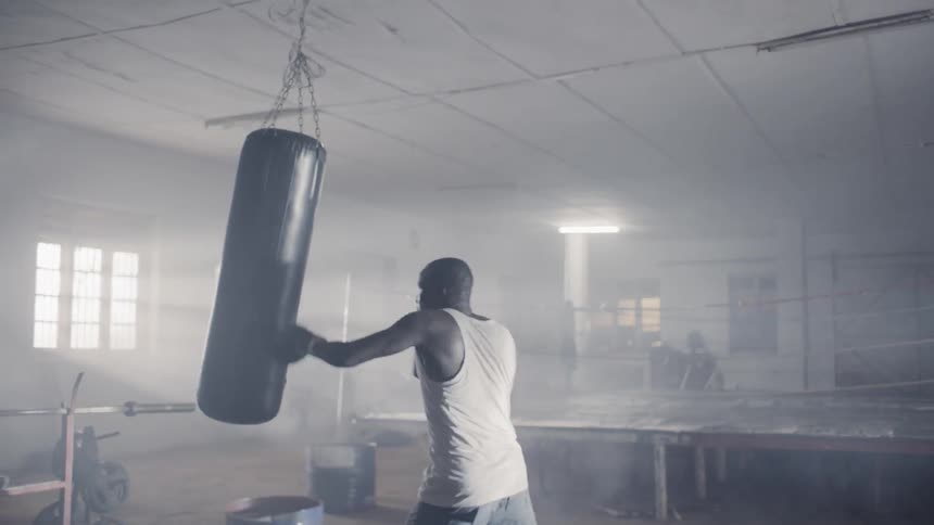 A man punches the black heavy bag