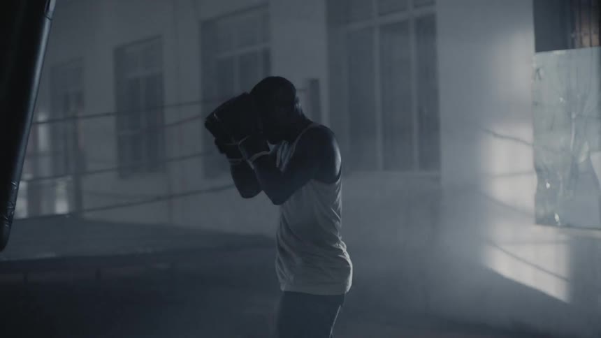 A man punches the heavy bag inside the gym