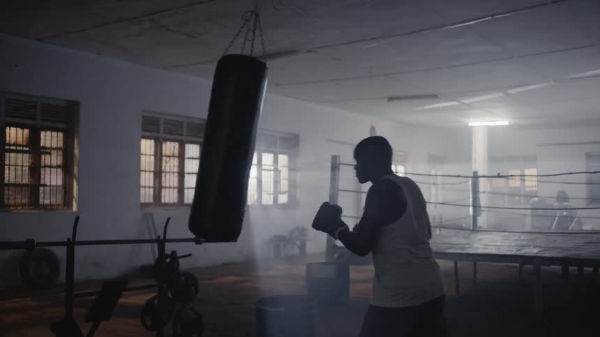 Man is boxing a punching bag in gym training room