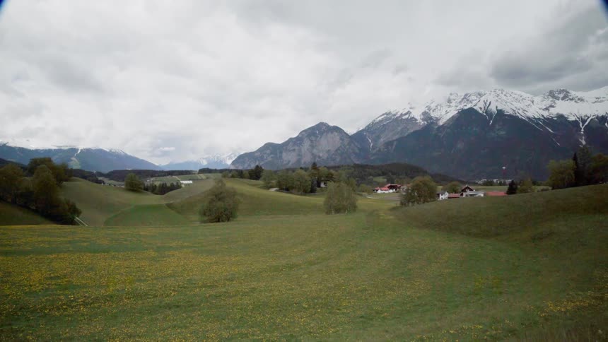 Clouds covering snowy mountains and meadows in the country