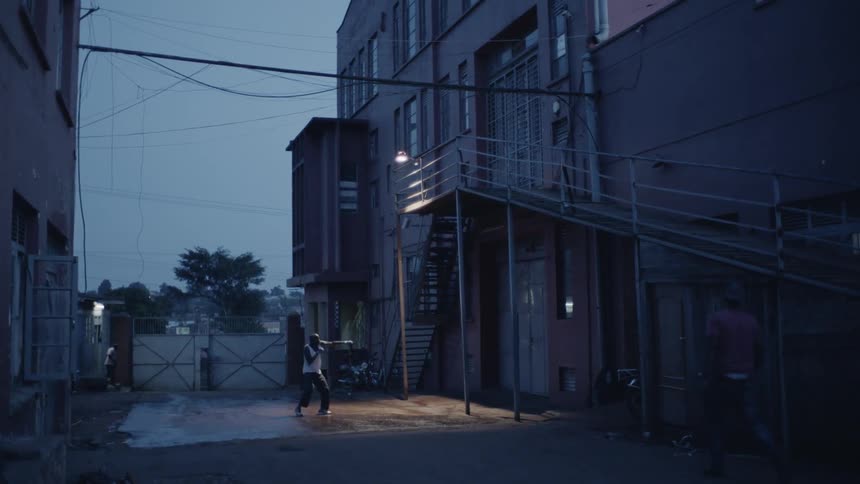 Man is practicing boxing outside in city at night