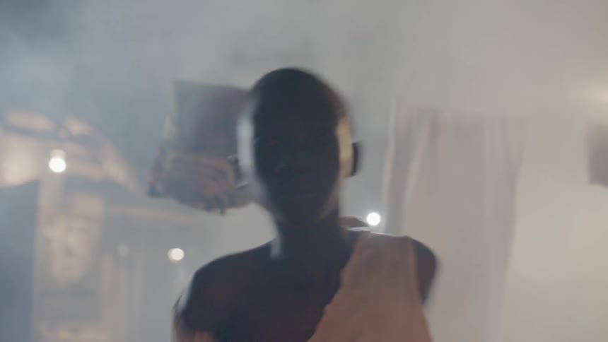 A boy runs through laundry hanging out to dry