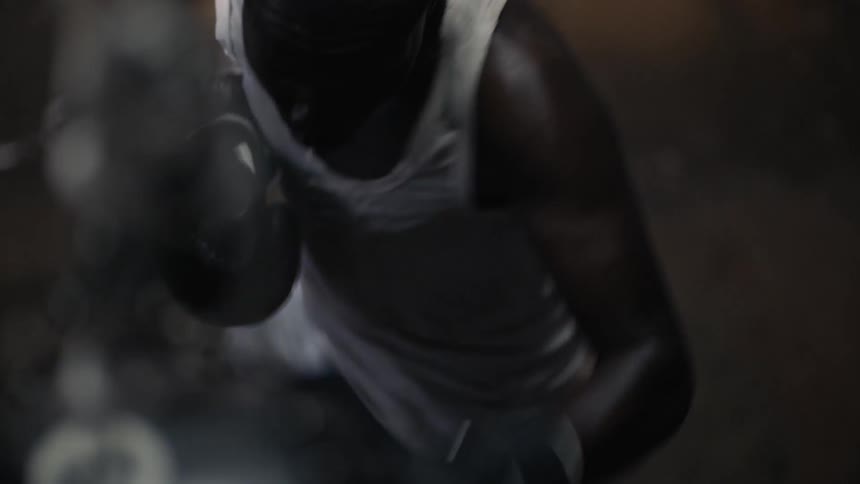 A man is punching in the gym hitting the heavy bag