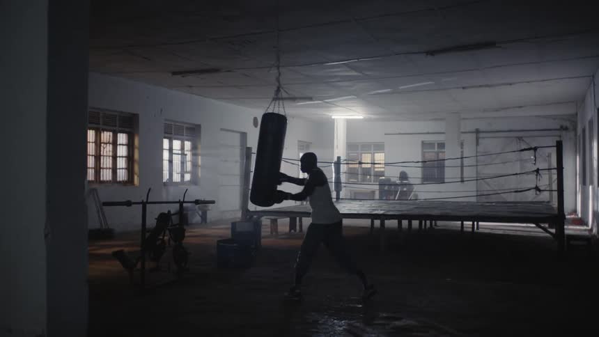 Man is boxing a punching bag in gym training room
