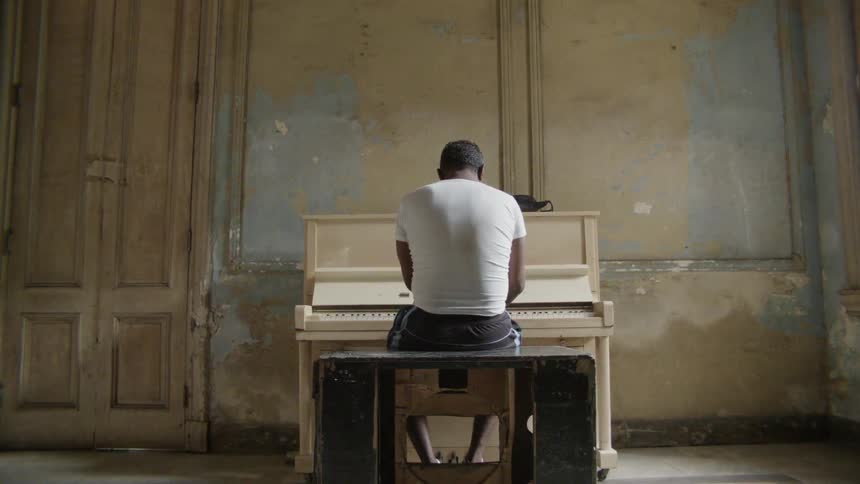 Man is playing piano in empty room