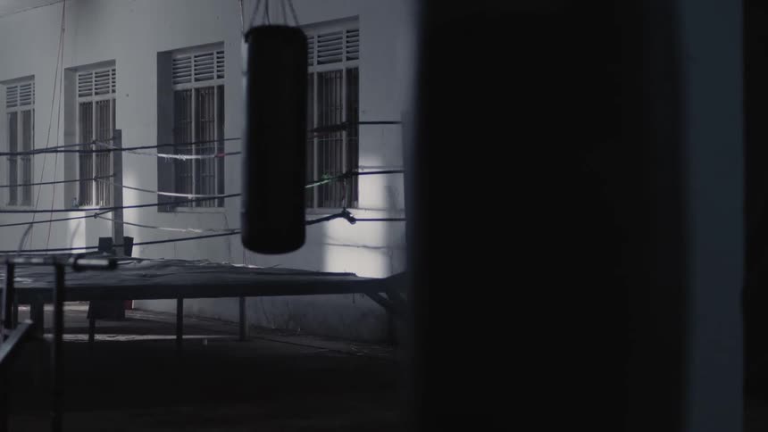 A boxer punches the air in a boxing ring