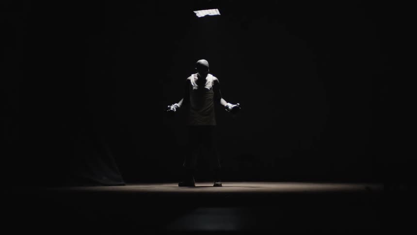 Confused man wearing boxing is looking around in dark room