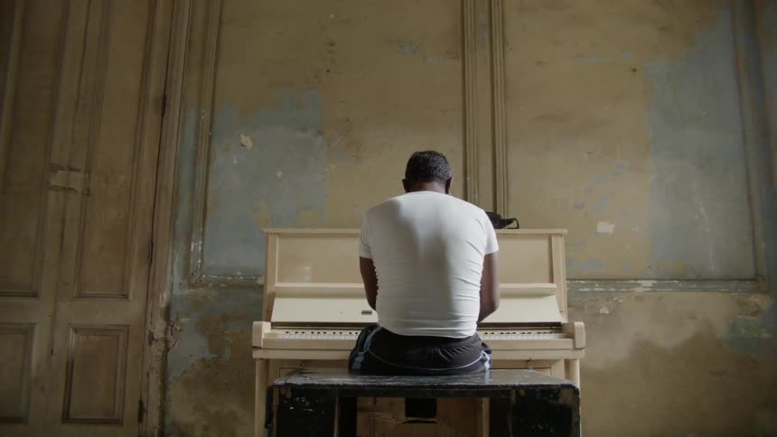 Man plays a piano in a large room