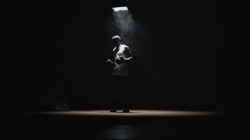 A boxer looks around a dark room