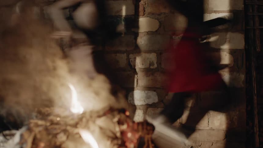 Boys run by a fire outside