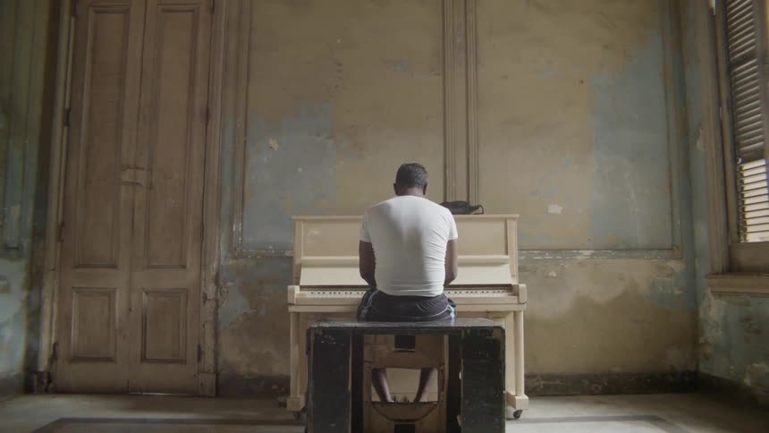 A man is sitting down playing the piano