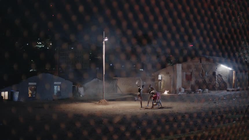 Three men beat up on another man under the night sky