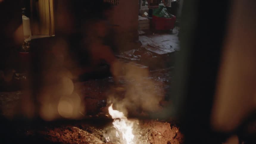 Teenagers run by a fire burning outside